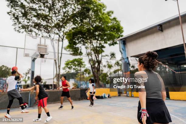 basketball player woman playing with friends on a sport court - streetball stock pictures, royalty-free photos & images