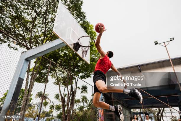 jóvenes jugando al baloncesto en una cancha deportiva - mate de baloncesto fotografías e imágenes de stock
