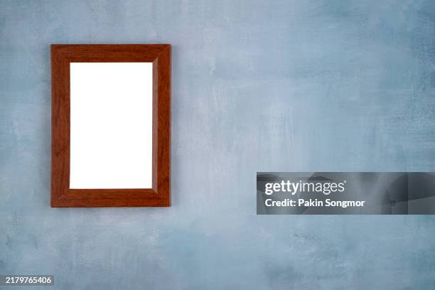 blank picture frames hanging on blue cement wall. - empty art gallery stock pictures, royalty-free photos & images