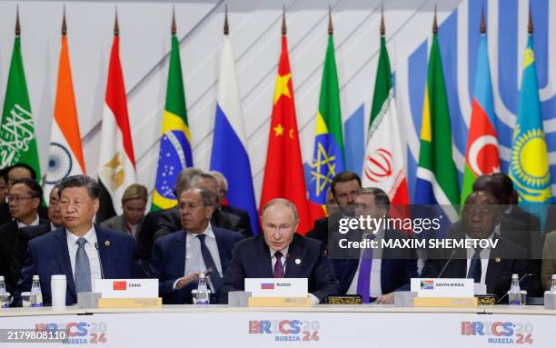 Officials, including South Africa's President Cyril Ramaphosa, Russia's President Vladimir Putin and China's President Xi Jinping, attend a plenary...