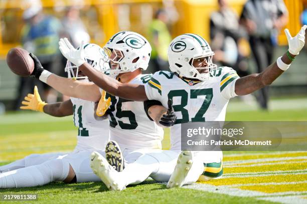 Tucker Kraft celebrates with Romeo Doubs of the Green Bay Packers after a second-quarter touchdown against the Houston Texans at Lambeau Field on...