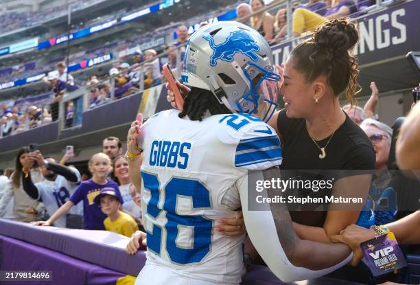 Jahmyr Gibbs of the Detroit Lions hands the ball to his girlfriend Nicole Anderson after scoring a touchdown in the second quarter of a game against...