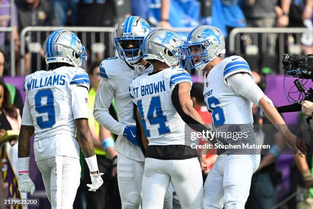 Jared Goff of the Detroit Lions celebrates with Amon-Ra St. Brown after a touchdown in the second quarter of a game against the Minnesota Vikings at...