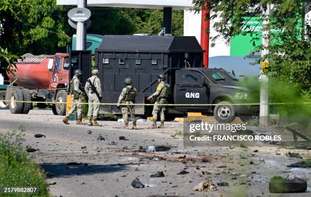 Mexican army soldiers stand next to a homemade armored vehicle with alleged identification of a drug cartel after an armed confrontation in Las...
