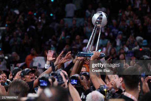 New York Liberty players hoist the WNBA Championship Trophy after winning Game Five of the WNBA Finals at Barclays Center on October 20, 2024 in New...