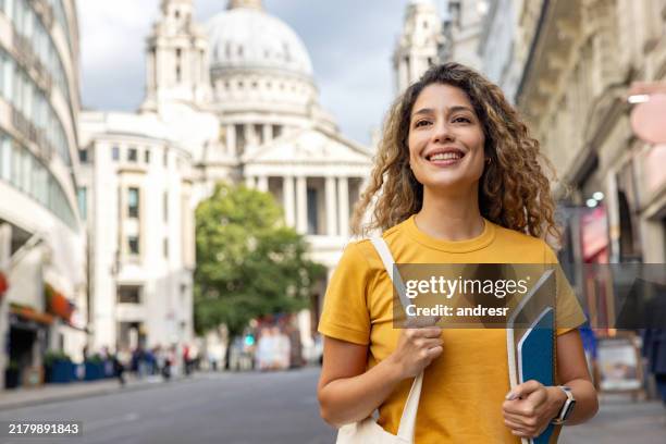 studente inglese felice che cammina per le strade di londra con in mano i quaderni - lingua inglese foto e immagini stock
