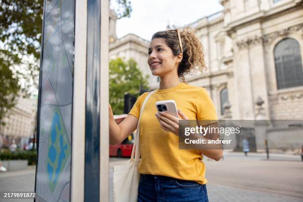 tourist in london, der an einem informationspunkt auf der straße auf eine digitale karte schaut - information stock-fotos und bilder