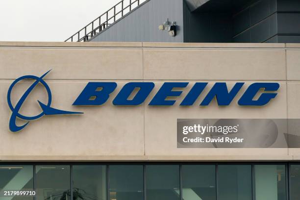 Boeing sign is seen on the exterior of a building as Boeing workers gather on a picket line near the entrance to a Boeing facility during an ongoing...