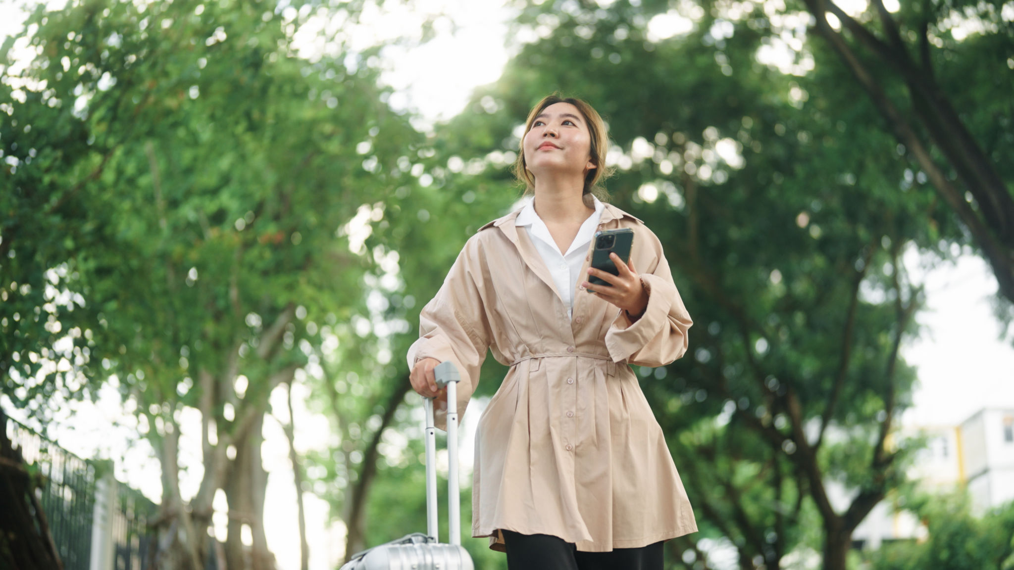Businesswoman using smartphone while travelling to her Airbnb Businesswoman using smartphone while travelling to her Airbnb