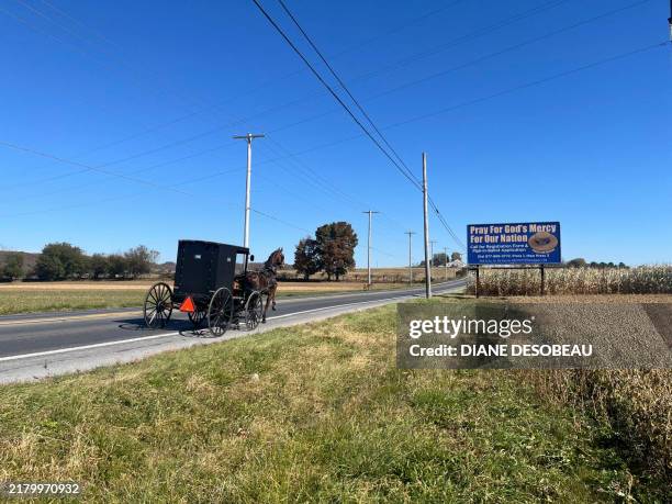 An Amish buggy rides in Lancaster, Pennsylvania, October 17, 2024. The Amish people of Lancaster, Pennsylvania, are a throwback to another era, with...