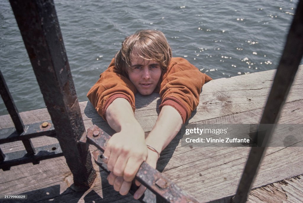 Cane Devore American actor Cain Devore, wearing an orange jacket, clinging to a ...
