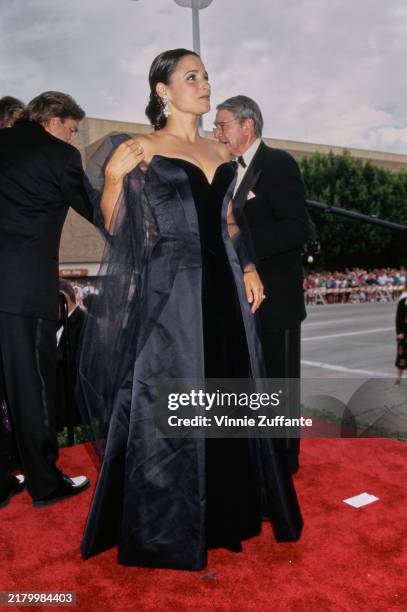 American actress and comedian Julia Louis-Dreyfus, wearing a black-and-midnight blue strapless evening gown, with a sheer black evening wrap, attends...