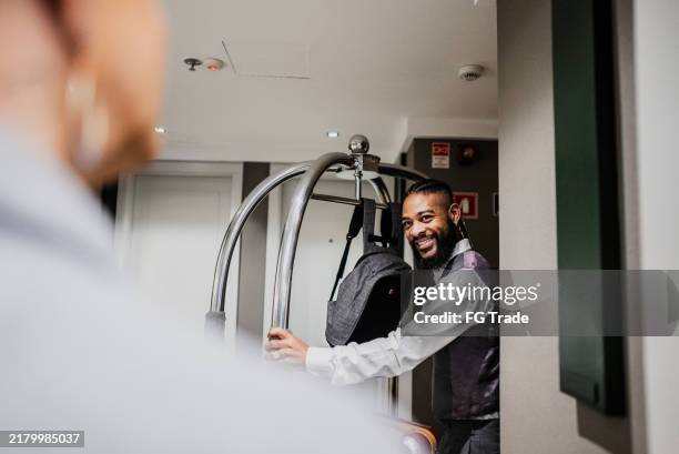 bellhop serving customer in a hotel - bellhop stock pictures, royalty-free photos & images