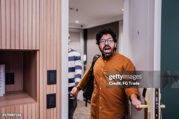 schwules paar bei der ankunft im hotelzimmer - hotelzimmer tür stock-fotos und bilder