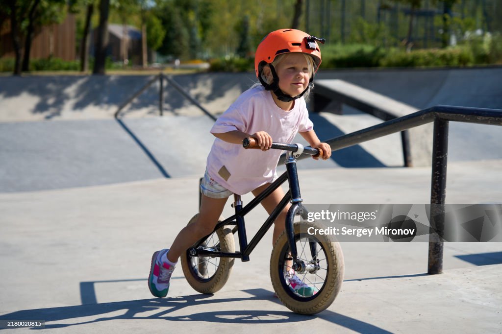 Child Pushing Balance Bike Up Ramp