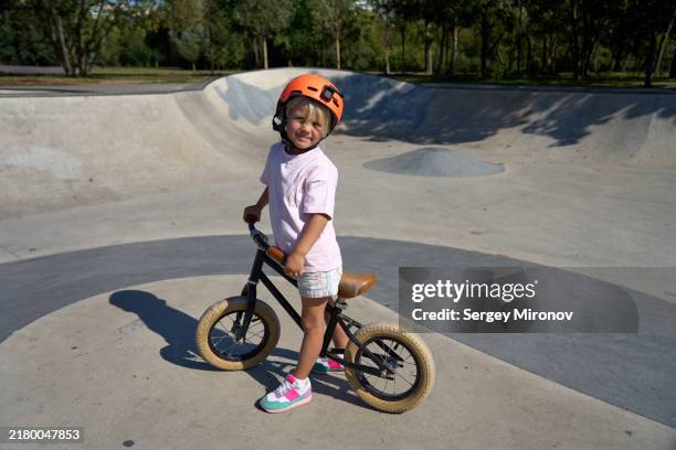 child with balance bike in skatepark - baby girls stock pictures, royalty-free photos & images