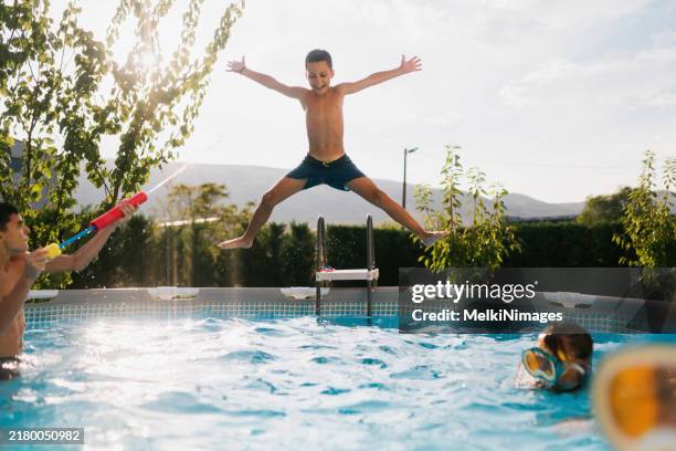 teenagers having fun jumping in the swimming pool - piscina autoportante imagens e fotografias de stock