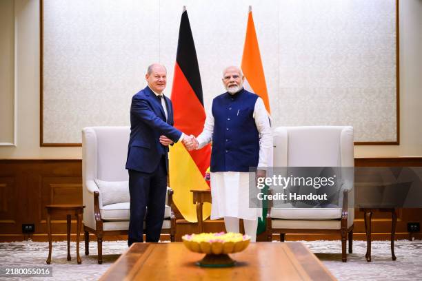 In this handout image provided by the German Government Press Office , German Chancellor Olaf Scholz shakes hands with Prime Minister of India...