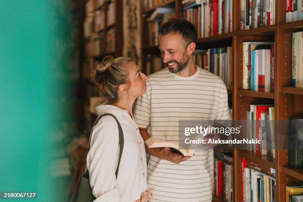 coppia sorridente ad un appuntamento in una libreria - libreria foto e immagini stock