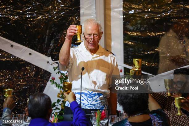 Britain's King Charles III raises his glass at the CHOGM Reception & Dinner at the Robert Louis Stevenson Museum, near Apia on October 25, 2024 in...