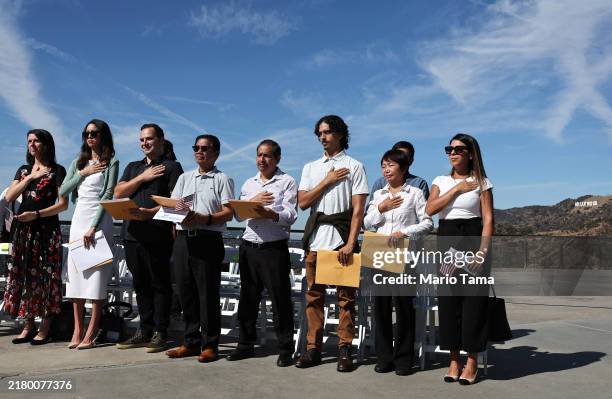 New U.S. Citizens recite the pledge of allegiance during a special naturalization ceremony on the Hollywood Sign Terrace at historic Griffith...