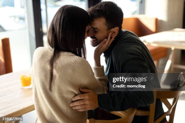 junges paar, das seine gemeinsame zeit in einem café genießt - verlieben stock-fotos und bilder