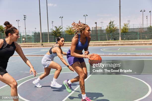 women playing pick up basketball in city - baloncesto femenino fotografías e imágenes de stock