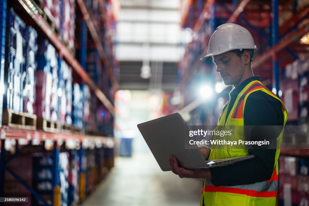 Warehouse Worker Using Laptop for Inventory Management