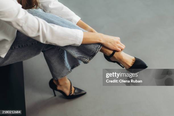 young woman lacing a black stiletto heel. - tacón de aguja fotografías e imágenes de stock