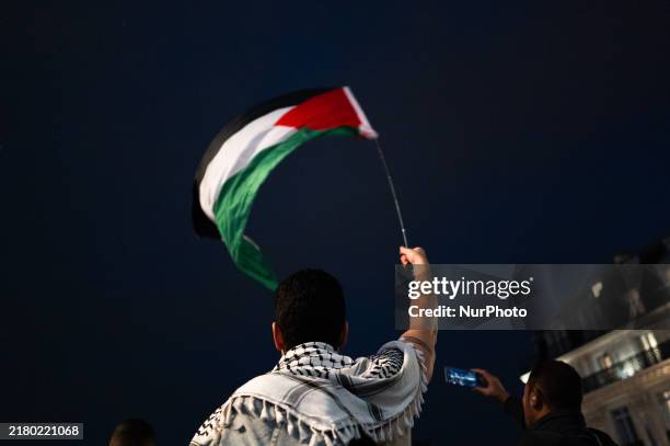 Protesters with flags attend a demonstration in support of Palestinian and Lebanese people as intense Israeli attacks occur in Gaza and Lebanon, in...