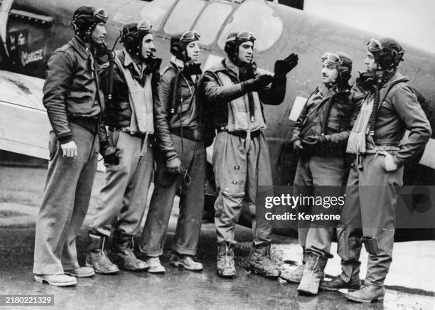 2nd Lieutenant Wah Kau Kong , Captain Wallace Emmer and Captain Don Beerbower watch as Lieutenant Jack Bradley uses his hands to describe his...