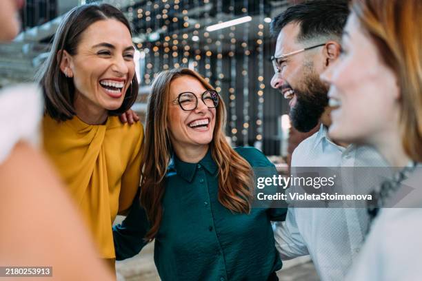 des collègues excités qui s’embrassent lors d’une célébration au bureau. - fête photos et images de collection