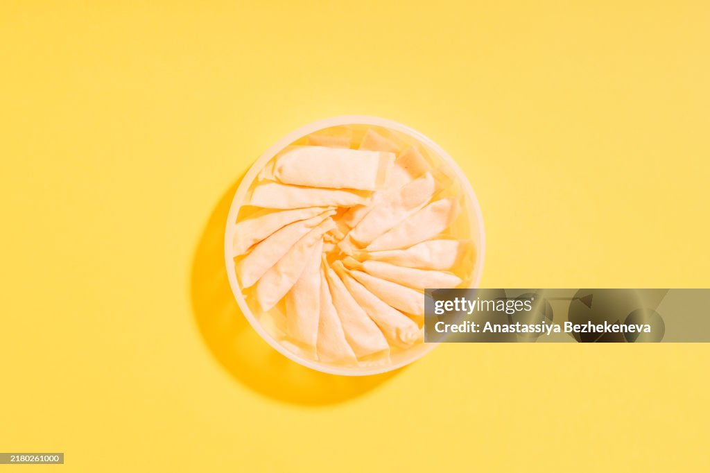 Fruit snus pouches in a jar on a yellow background
