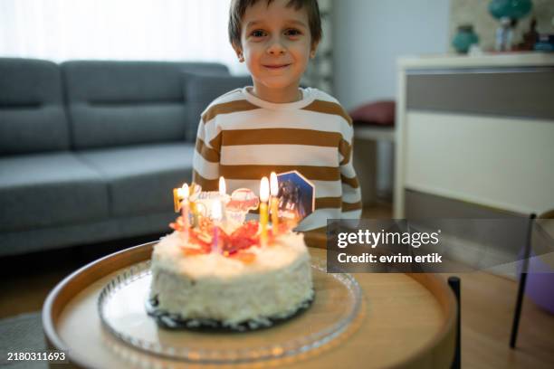 little kid boy celebrating his birthday and blowing candles - verjaardagstaart stockfoto's en -beelden
