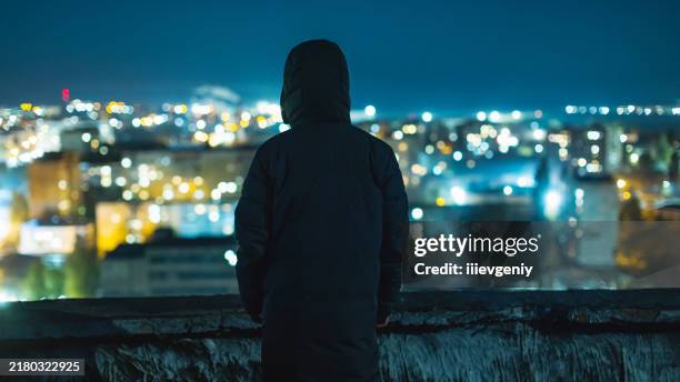 man silhouette against night city background. - animal behaviour stock pictures, royalty-free photos & images