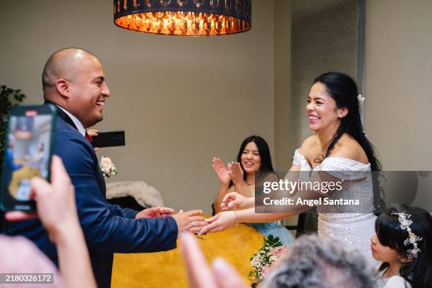 happy couple exchanging rings during wedding ceremony - promesas de matrimonio fotografías e imágenes de stock
