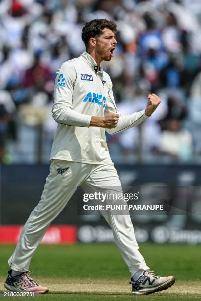 New Zealand's Mitchell Santner celebrates after taking the wicket of India's Yashasvi Jaiswal during the third day of the second Test cricket match...