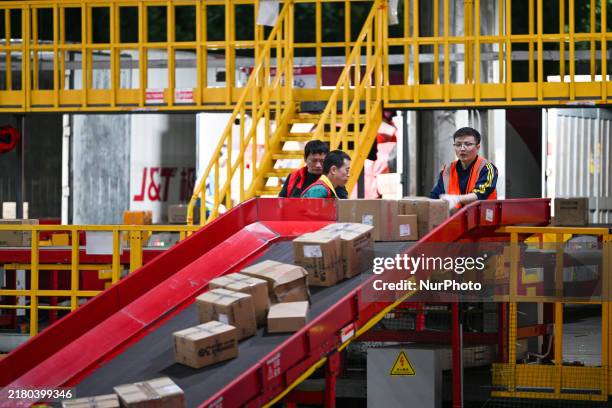 Workers sort express deliveries on an automated sorting line at the Jitu Express transit center in Nanjing, Jiangsu province, China, on October 26,...