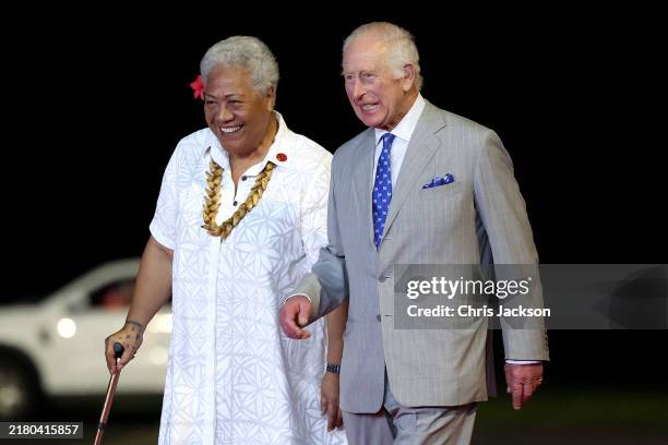 King Charles III walks with Prime Minister of Samoa Fiame Naomi Mata'afa after arriving at Faleolo International Airport for his official welcome on...