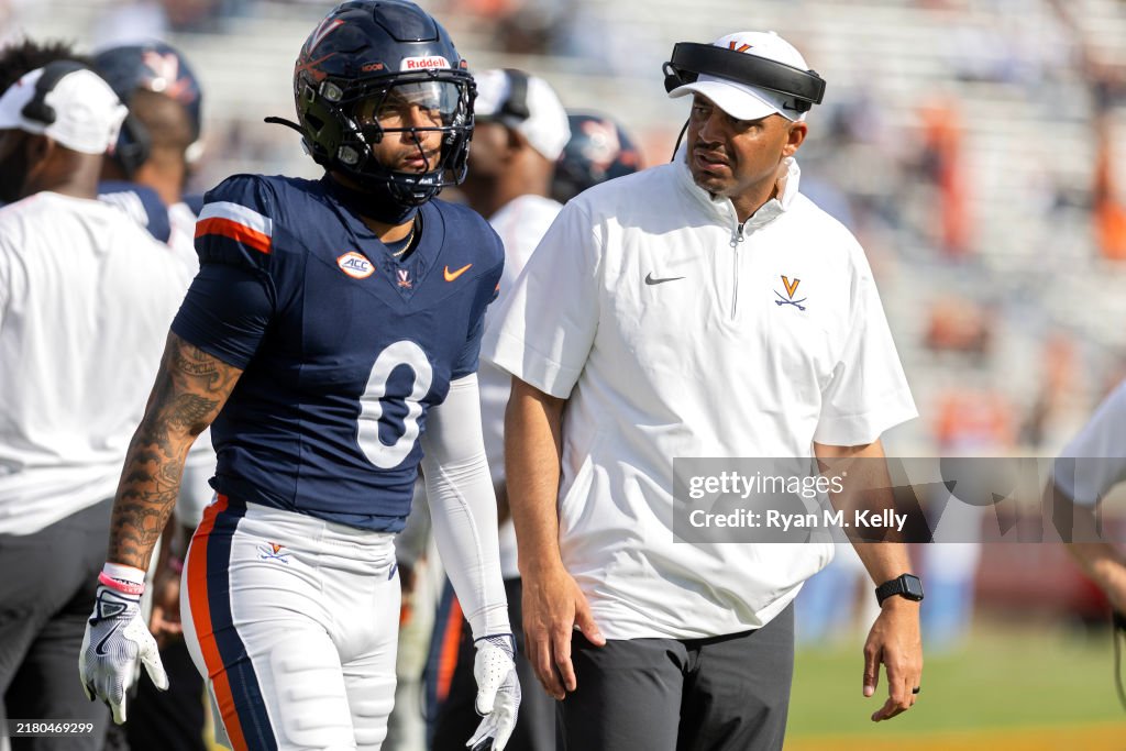 Head coach Tony Elliott talks to Antonio Clary of the Virginia... News