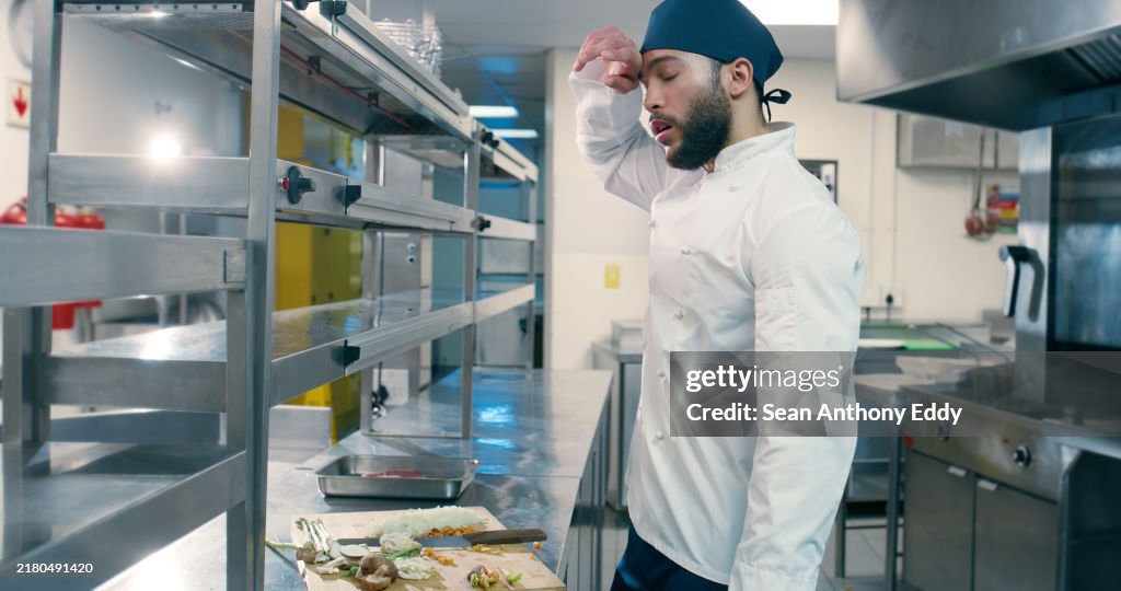 Hombre, chef y cansado en restaurante en cocina para cocinar, gourmet o verduras para el arte culinario con fatiga. Persona, preparación de comidas y agotamiento por la noche con el estrés, la comida o los servicios de catering en el bistró