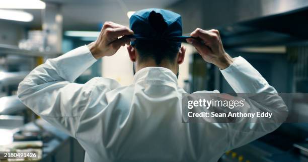 chef, kitchen and restaurant with hat tie and start dinner service at fine dining job with hospitality. man, back and professional culinary artist with catering and food prep job with gourmet cooking - koksmuts stockfoto's en -beelden