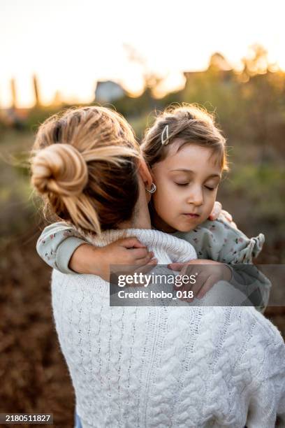 mom and her little daughter embracing in sunset - pear tree stock pictures, royalty-free photos & images