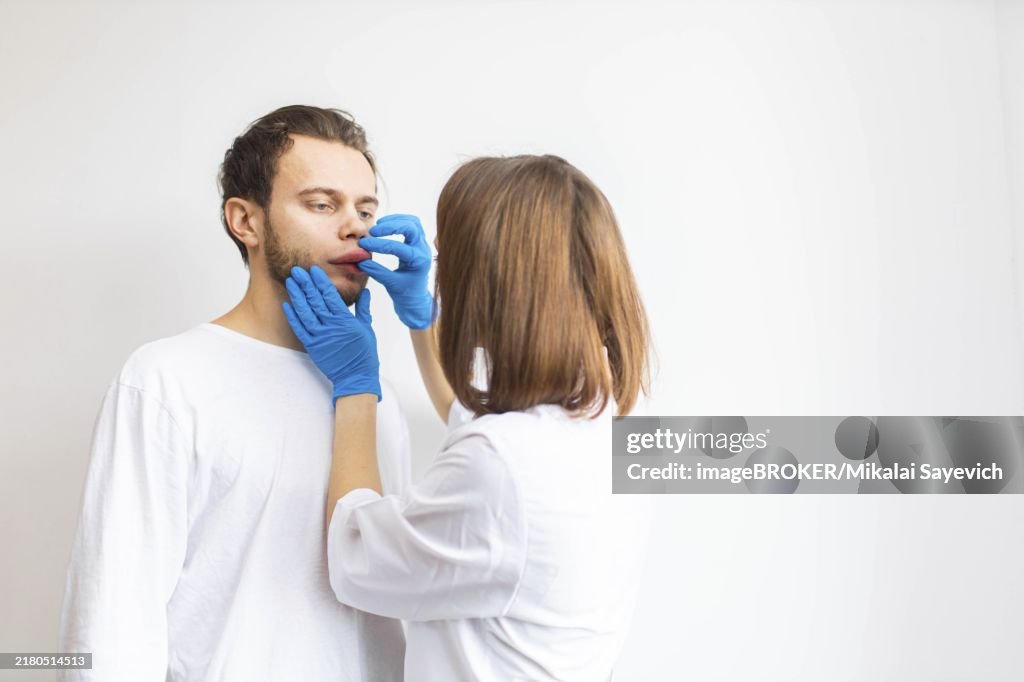 Doctor examines allergic swelling on the patient's lip, angioedema