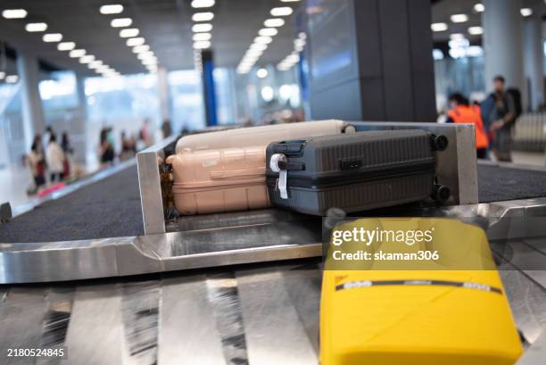 suitcase on airport baggage claim conveyor belt - área de retirada de bagagem - fotografias e filmes do acervo