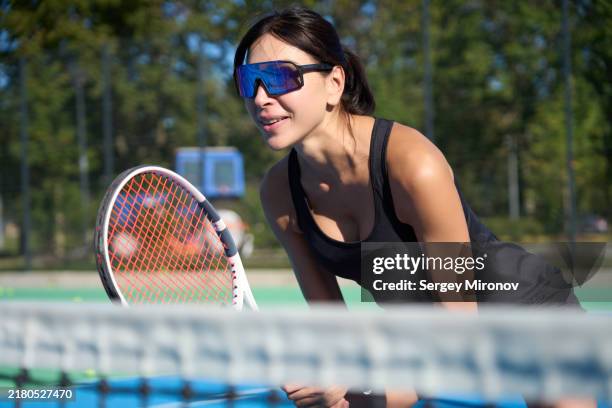 female tennis player concentrating at net during match - eyewear stock pictures, royalty-free photos & images