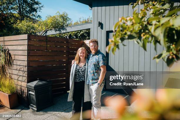 couple standing outside of modern home - homeowner stock pictures, royalty-free photos & images