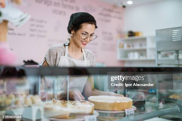 waitress at the display of pies and sweets - sweet shop stock pictures, royalty-free photos & images