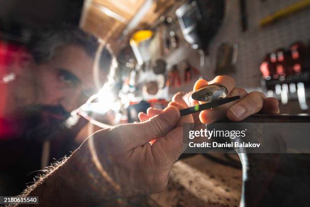 kunst aus schrott. künstlerhände stellen ring aus recyceltem metall her. - ungewöhnliche perspektive stock-fotos und bilder
