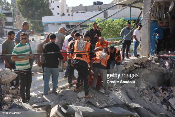 Residents and civil defense team conduct search and rescue operations after the Israeli army targeted Asma School, run by the UN agency for...
